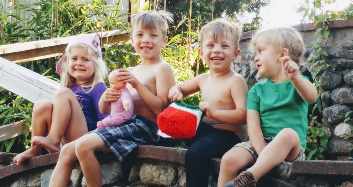 kids sitting on a stone wall