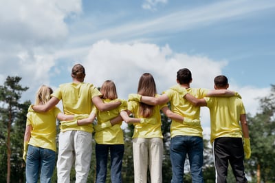 a team of volunteers standing in a line with their arms around one another